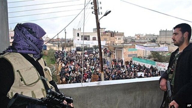 Syrian army defectors secure an anti-Syrian regime protest in the Deir Baghlaba area of Homs province, Jan. 27, 2012.