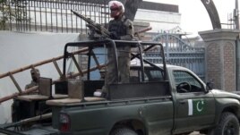 Pakistani security forces stand guard at the site of a deadly blast by four Taliban suicide bombers in Bannu, Pakistan, December 10, 2012.