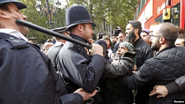 Police officers scuffle with demonstrators during a protest in support of Islamist cleric Abu Hamza al-Masri, during his appeal against extradition to the U.S., outside the High Court in London, October 5, 2012.