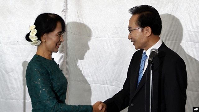 South Korean President Lee Myung-bak, right, shakes hands with Burma opposition leader Aung San Suu Kyi in Rangoon, May 15, 2012.