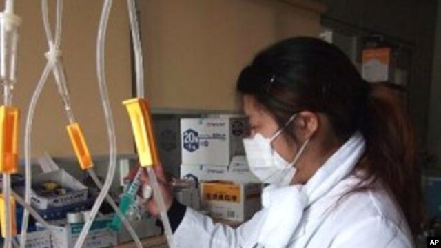 Nurse Tomimo Goto prepares medicine in the darkened ward of the Sen-en Hospital in Tagajo, Japan