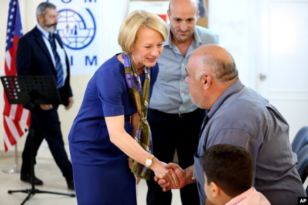 The U.S. ambassador to Jordan, Alice Wells, shakes hands with Syrian refugees ahead of their departure to the United States, Aug. 28, 2016.