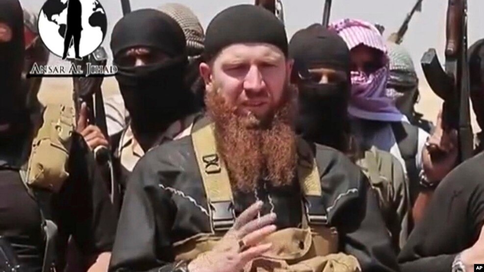 FILE - Abu Omar al-Shishani, seen in an image from video posted on social media June 28, 2014, stands among a group of fighters as Islamic State declares elimination of border between Iraq and Syria.