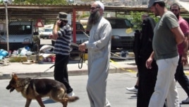 Ahmad Assir walks his dog with family members and bodyguards in Sidon July 5, 2012 (VOA/Jeff Neumann).