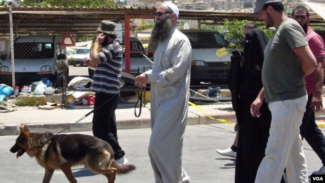 Ahmad Assir walks his dog with family members and bodyguards in Sidon July 5, 2012 (VOA/Jeff Neumann).