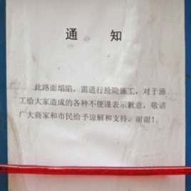Chinese notice hangs on a metal barrier of the construction site on Wangfujing Street in Beijing.