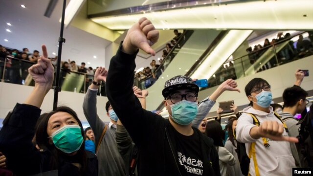 2月15日，香港一个购物中心里，港人与大陆游客发生摩擦。抗议者向陆客作出手势，表示不满。