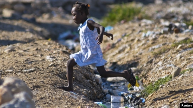 A girl jumps over an open sewage in Port-au-Prince, Sept. 4, 2012.