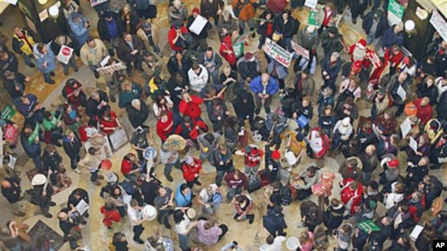 Demonstrators bang drums and chant inside the state Capitol during the eighth day of protesting against Governor Scott Walker's bill to eliminate collective bargaining rights for many state workers,  in Madison, Wis., February 22, 2011