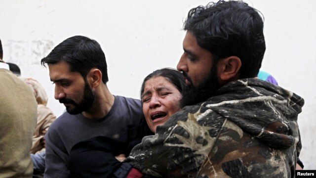 Des membres de famille de Nasima Bibi - agent de santé travaillant dans la campagne de vaccination anti-polio qui a été tuée par balle - pleurant sa mort à la morgue de l'hôpital de Karachi 18 décembre, 2012.
