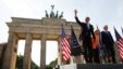 Flanked by Chancellor Angela Merkel and Berlin Mayor Klaus Wowereit, President Barack Obama waves at the Brandenburg Gate, in Berlin, June 19, 2013.
