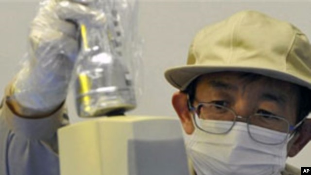 A staff member checks the level of radiation on an industrial product produced in Fukushima Prefecture at Fukushima Technology Center in Koriyama, northeastern Japan, April 4, 2011