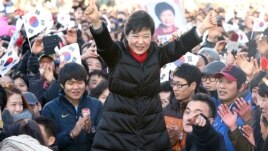 South Korea's presidential candidate Park Geun-hye of ruling Saenuri Party raises her arms  during her presidential election campaign in Busan, South Korea, December 18, 2012.