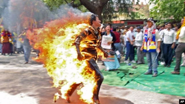 Jamphel Yeshi, a Tibetan exile, runs after setting himself on fire during a protest against the upcoming visit of Chinese President Hu Jintao to India in New Delhi, March 26, 2012.