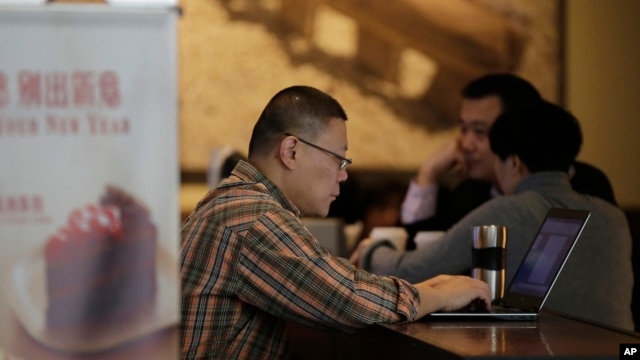 FILE - A man surfs Internet on his laptop computer at a Starbucks cafe in Beijing, Feb. 16, 2015. 