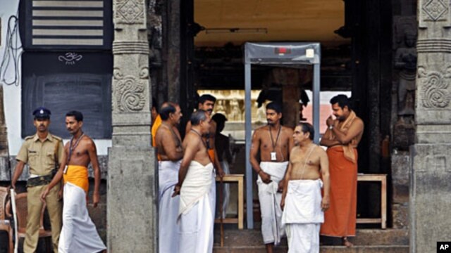 A policeman stands guard as temple staff crowd at the north side entrance of the 16th century Sree Padmanabhaswamy Temple in Trivandrum, India, July 6, 2011