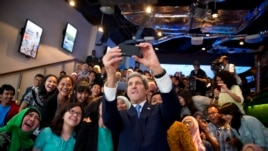 Secretary of State John Kerry takes a selfie with a group of students before delivering a speech on climate change on Sunday, Feb. 16, 2014, in Jakarta.