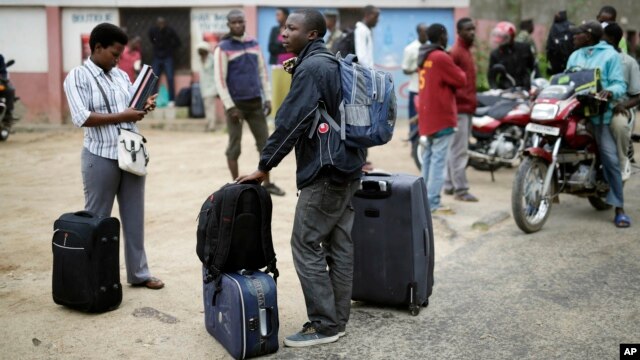 Students carry their belongings as they leave the Kiriki University campus in Bujumbura, April 30, 2015.