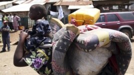 A woman carries her child in Minova, 45 kilometers west of Goma, DRC, November 26, 2012. 