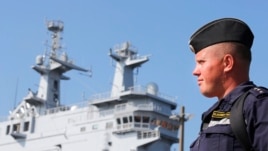 FILE - A Russian sailor stands next to the Vladivostok warship in the port of Saint-Nazaire, western France. 