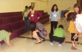 Teachers measure the distance of five steps during a Singapore Math training session.