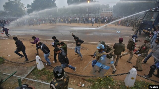 Polisi India menggunakan meriam air dan gas air mata untuk membubarkan para pengunjuk rasa di New Delhi (23/12). Seorang polisi yang terluka parah pasca bentrokan dengan para demonstran ini dikabarkan meninggal dunia di rumah sakit, hari ini.