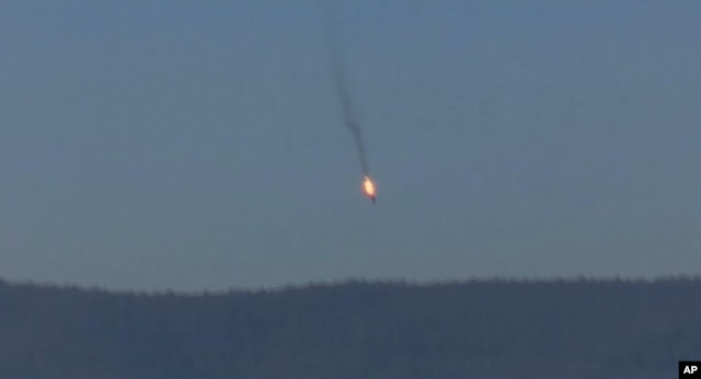 This frame grab from video by Haberturk TV, shows a Russian warplane on fire before crashing on a hill as seen from Hatay province, Turkey, Nov. 24, 2015.
