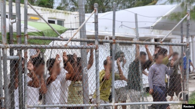 Người xin tị nạn đứng sau một hàng rào tại trung tâm giam giữ Manus ở Papua New Guinea, ngày 21 tháng 3, 2014.
