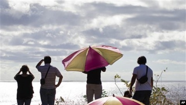 People look out to sea from a hill top after an alert of tsunami was launched in Hanga Roa, Easter Island, Chile, March 11, 2011