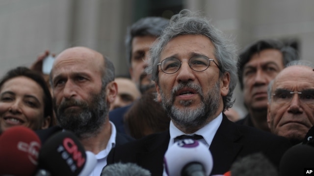 Can Dundar, the editor-in-chief of opposition newspaper Cumhuriyet, right, and Erdem Gul, left, the paper's Ankara representative, speak to the media after their trial in Istanbul, March 25, 2016.