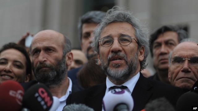 FILE - Can Dundar, the editor-in-chief of opposition newspaper Cumhuriyet, right, and Erdem Gul, left, the paper's Ankara representative, speak to the media after the opening of their trial in Istanbul, March 25, 2016.