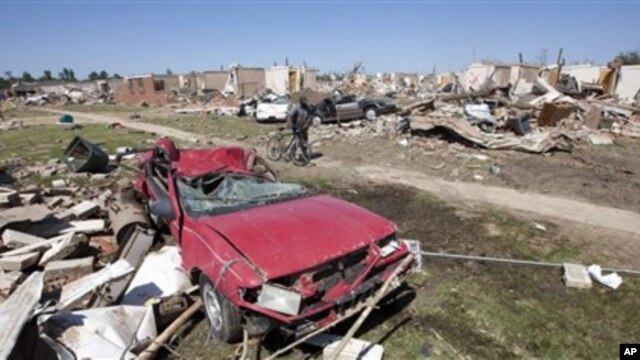 Calvin Smith of Tuscaloosa, Alabama, pushes his bike past tornado demolished homes in Tuscaloosa, Alabama, April 29, 2011