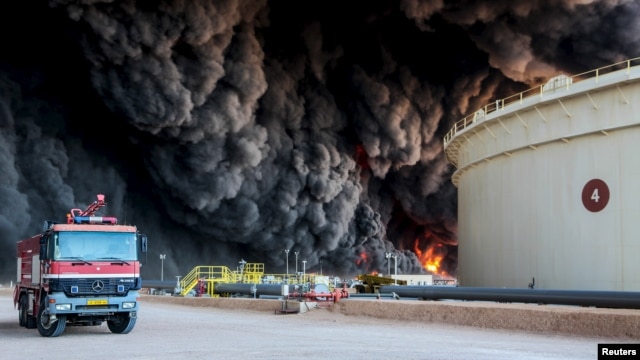 FILE - Fire rises from an oil tank in the port of Es Sider, in Ras Lanuf, Libya, Jan. 6, 2016. A Petroleum Facilities Guards blamed the blazes on attacks by Islamic State militants.