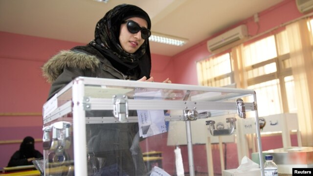 A woman casts her ballot at a polling station in Ardiyah, Kuwait, December 1, 2012.