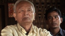 Nuon Chea (left), "Brother Number Two" of the Khmer Rouge regime, sits with documentary filmmaker Thet Sambath during an interview.