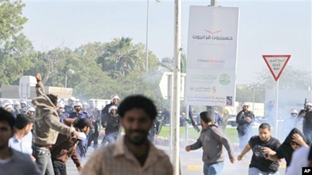 Riot police chase Bahraini demonstrators as they disperse a protest with tear gas in the village of Duraz, Bahrain, outside the capital of Manama, February 14, 2011