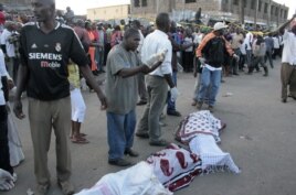 Residents prepare to carry the slain body of a woman killed during an explosion in a passenger mini-bus (matatu) in the Eastleigh neighbourhood of Kenya's capital Nairobi, November 18, 2012.