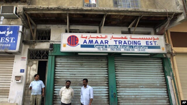 Men stand in front of closed shops near Pearl Square in the center of Manama, Mar 15 2011