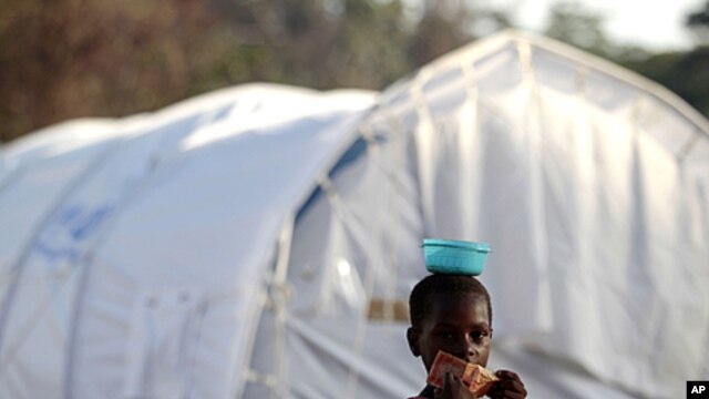 An Ivorian girl holds a 10 Liberian dollar banknote as she goes to buy food for her family in a camp housing more than 2,600 Ivorian refugees, with more arriving daily, in Solo Town, Liberia, May 25, 2011.