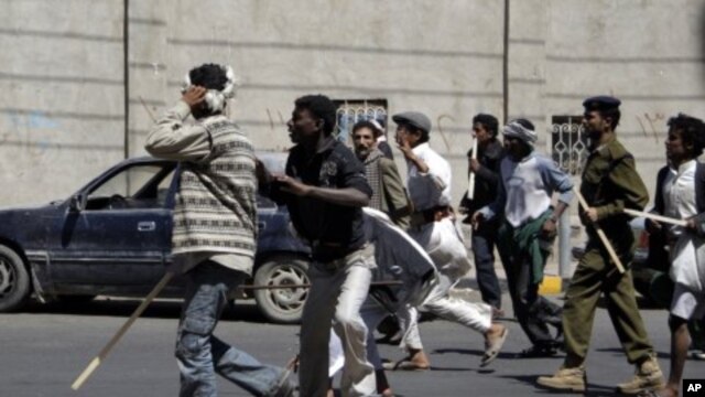 Government backers chase anti-government protesters during clashes in Sanaa, February 14, 2011
