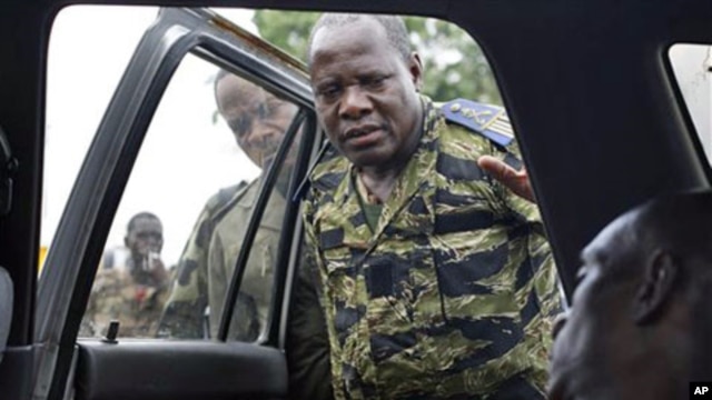 Soldiers loyal to Alassane Ouattara look at the body of a civilian who they say died as they tried to transport him for medical help at their operating base, after he was allegedly shot by militiamen loyal to Laurent Gbagbo, in Abidjan, Ivory Coast, April