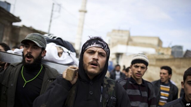 Free Syrian Army fighters carry the body of a comrade killed by the Syrian Army in Azaz, Syria, Dec. 13, 2012