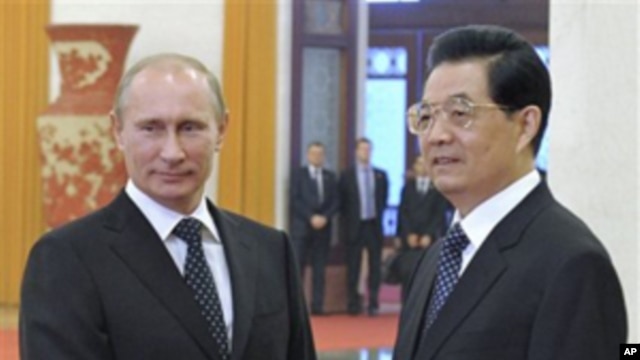 Chinese President Hu Jintao (r) and Russian Prime Minister Vladimir Putin pose prior to the talks at the Great Hall of the People in Beijing, China, Oct. 12, 2011
