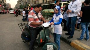 An Egyptian on his motorbike signs a petition for Tamarod, Arabic for "rebel", a campaign calling for the ouster of Egyptian President Mohammed Morsi and for early presidential elections in the Shubra neighborhood in Cairo, Egypt, June 2, 2013. 
