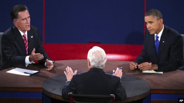 Republican presidential nominee Mitt Romney answers a question as President Barack Obama listens during the third presidential debate at Lynn University  in Boca Raton, Florida, October 22, 2012.