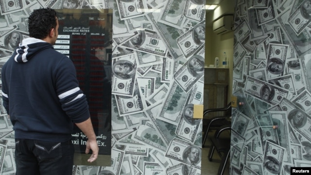 A man stands outside an exchange bureau in Cairo, December 30, 2012.