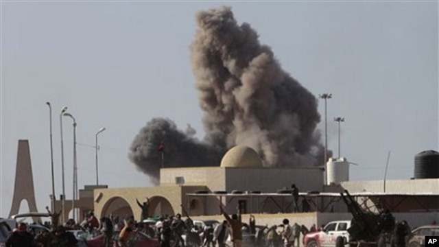 Anti-Gadhafi rebels run away as smoke rises following an air strike by Libyan warplanes near a checkpoint of the anti-Libyan Leader Moammar Gadhafi rebels, in the oil town of Ras Lanouf, eastern Libya, March 7, 2011