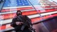 FILE - A heavily armed New York city police officer stands guard at the armed forces recruiting center in New York's Times Square, Nov. 14, 2015.