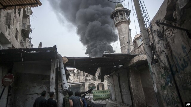 Khói bốc lên sau các vụ pháo kích vào thị trấn Jedida trong thành phố Aleppo.