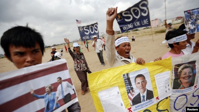 Residents who face eviction from their homes display signs with pictures of U.S. President Barack Obama and Secretary of State Hillary Clinton, as they ask for help in protecting their rights during a protest ahead of their visit in Phnom Penh November 18.